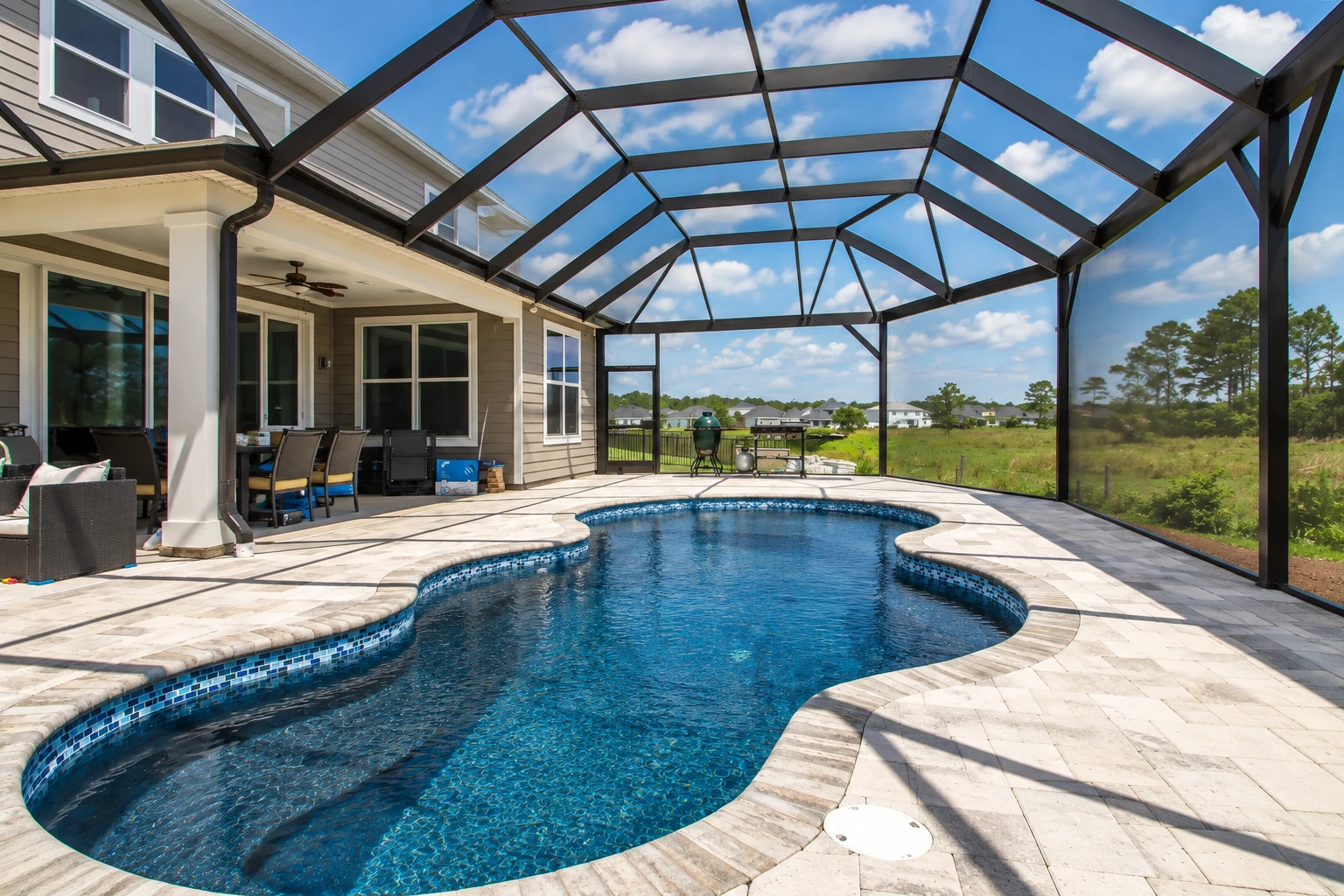 Patio enclosure with a black-framed transparent roof around a swimming pool and paved deck.